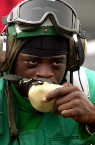 US Navy 030517-N-2385R-001 Airman Leguan Penigo mans the jet blast deflector (JBD) sound-powered phones for an inspection prior to flight operations