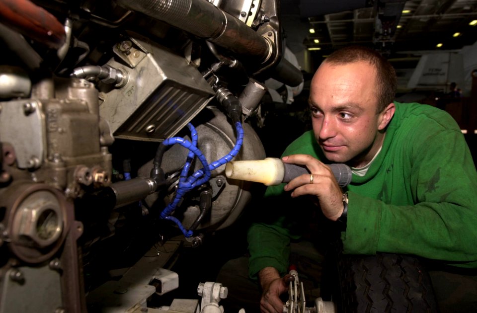 US Navy 030601-N-2143T-001 Aviation Machinist's Mate 3rd Class Bart Szczepanski from Lemoore, Calif., inspects an engine