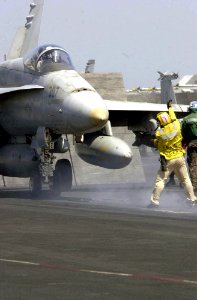 US Navy 030702-N-9319H-011 Chief Aviation Boatswain's Mate Michael Lauricella from Houston, Texas, directs an F-A-18 Hornet