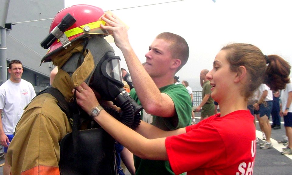 US Navy 030610-N-0000X-006 Damage Controlman 3rd Class Krystle Vernon (right) checks a team of 3rd class midshipmen's work suiting up in firefighting equipment during Damage Control Olympics