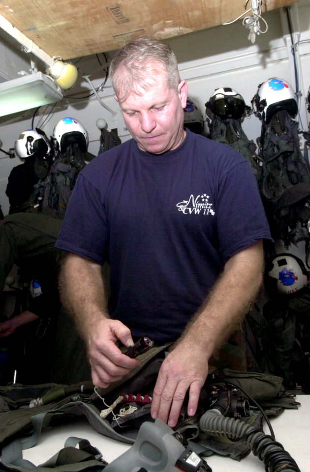US Navy 030625-N-1577S-001 Aircrew Survival Equipmentman 1st Class Gene Martin inspects a survival vest before issuing it to aircrew aboard USS Nimitz (CVN 68)