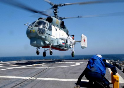 US Navy 030612-N-4374S-001 A chock and chain crew, part of the flight deck team aboard the Aegis cruiser USS Vella Gulf (CG 72) remains in a ready position while a Russian Helix K-27 helicopter lands aboard ship