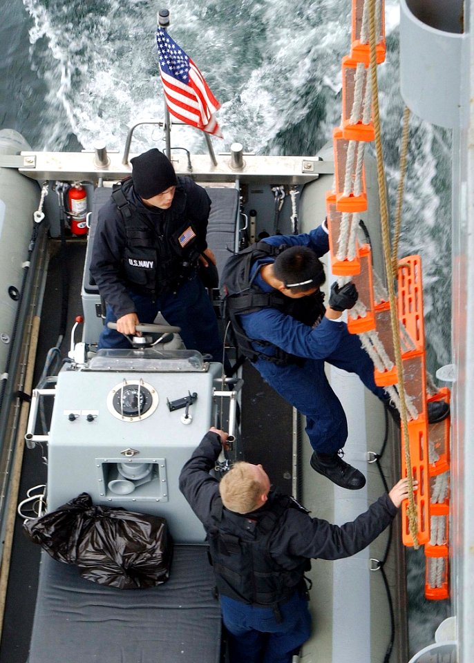 US Navy 030612-N-4374S-004 A member of the Vessel Boarding Search and Seizure (VBSS) team from the Aegis class, guided missile cruiser USS Vella Gulf (CG 72) boards a rigid hull inflatable boat (RHIB)