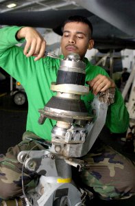 US Navy 030806-N-0413R-002 Aviation Machinist's Mate 2nd Class Adan Garcia, of New Orleans, La., installs a spindle for a SH-60 helicopter rotor head aboard the nuclear powered aircraft carrier USS Nimitz (CVN 68)