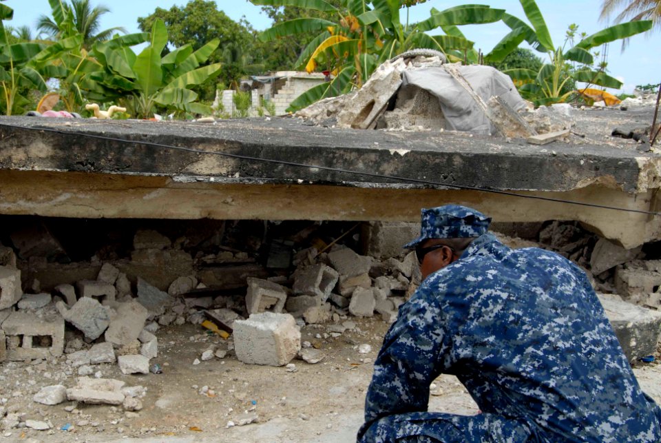 US Navy 100119-N-7653W-235 Master Chief Andrew Thompson looks at a collapsed in Port-Au-Prince, Haiti
