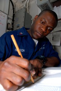 US Navy 090226-N-9950J-018 Storekeeper 2nd Class Tareq Hudson looks through the Hazardous Material User's Guide