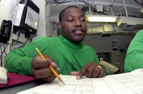 US Navy 030624-N-2385R-001 Aviation Maintenance Administrationman 1st Class Shawn Phillips reviews the evening flight plan
