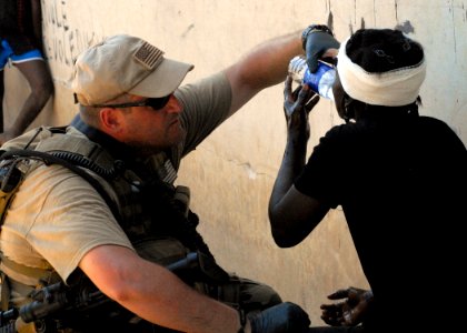 US Navy 100202-N-4971L-132 Sailor provides first aid to Haitian woman