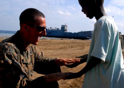 US Navy 100213-N-2000D-108 A Marine plays with a Haitian child photo