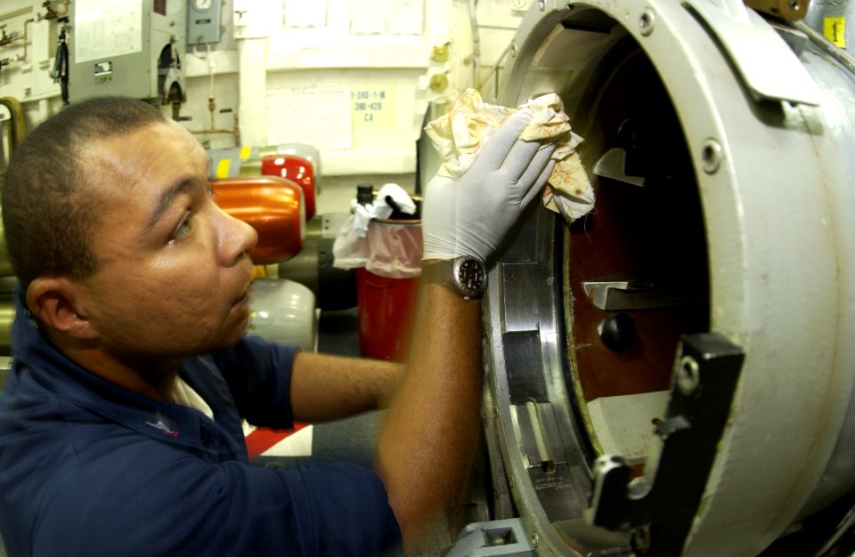 US Navy 030819-N-2613R-006 Torpedoman 3rd Class Jhonny Bardsley from Chicago, Ill., conducts quarterly maintenance on one of the ship's MK-32 Surface Vessel Torpedo Tubes