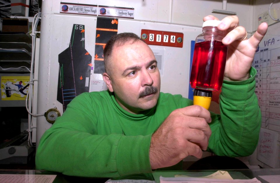 US Navy 030623-N-0413R-003 Senior Chief Aviation Structural Mechanic Steve Haugh inspects a hydraulic fluid sample for foreign particles aboard the aircraft carrier, USS Nimitz (CVN 68)