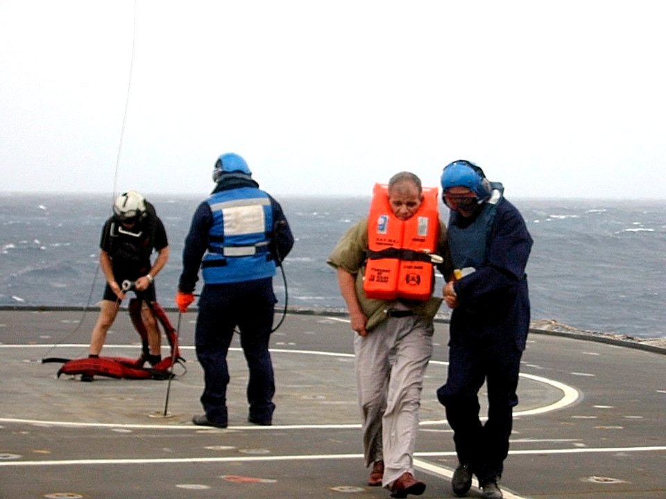 US Navy 030624-D-0000X-002 A rescued crewmember from the Egyptian cargo ship MV Green Glory is escorted across the ship's flight deck aboard the British Royal Navy's landing ship logistic RFA Sir Tristram (L 3505)