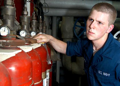 US Navy 030515-N-1512S-040 Machinist's Mate 3rd Class Daniel Griffin wipes down Halon 1301 bottles in the aft main machinery room aboard the amphibious assault ship USS Kearsarge (LHD 3)
