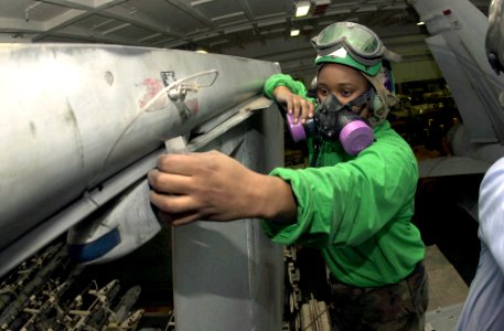 US Navy 030808-N-2143T-001 Aviation Machinist's Mate Airman Starcia Cousar, of Rock Hill, S.C., sands down corrosion from an aircraft wing in a hanger bay aboard USS Nimitz (CVN 68)