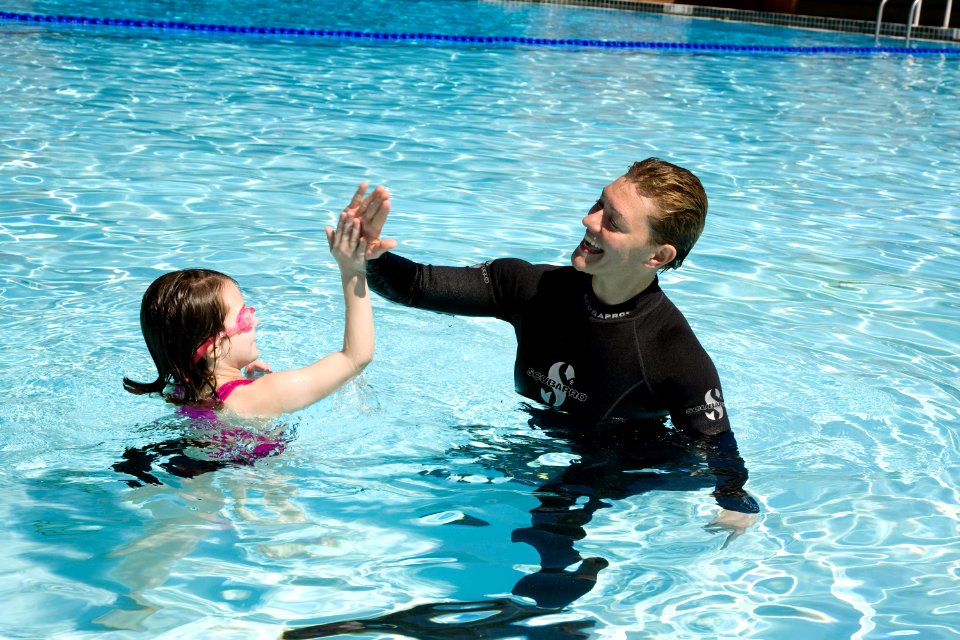 US Navy 100313-N-3271W-074 Chief Master-at-Arms Cris Miller swims with a young patron at Adventure Island waterpark