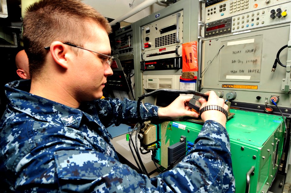 US Navy 100505-N-6935K-004 Aviation Electrician's Mate 3rd Class Shane Rogers checks a power supply unit for aircraft