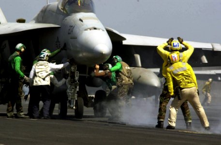 US Navy 030701-N-9319H-007 Flight deck handlers direct an F-A-18E Super Hornet into position for launch, from one of the four steam powered catapults on the flight deck aboard USS Nimitz (CVN 68)