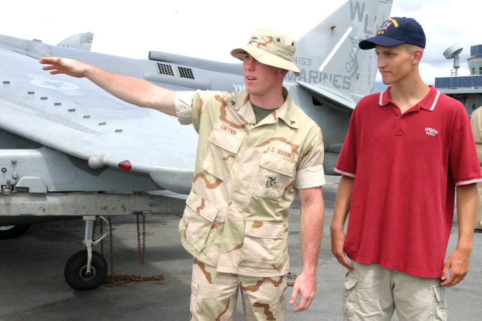 US Navy 030716-N-3228G-005 U.S. Marine Cpl. Quentin Gwynn, a support equipment technician aboard the amphibious assault ship USS Bonhomme Richard (LHD 6) gives a tour of the ship to 16 year-old Adam Smith