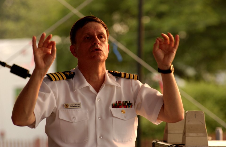 US Navy 030704-D-3645W-157 Navy Band leader Capt. Ralph Gambone conducts the U.S. Navy Concert Band at the Sylvan Theater grounds during a July 4th celebration