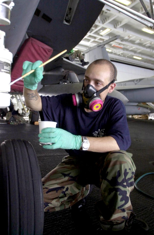 US Navy 030716-N-0413R-008 Aviation Structural Mechanic 3rd Class Ivan Irizarry of Harlem, N.Y., applies a coat of paint to the nose landing gear of an aircraft, in the Hanger Bay aboard USS Nimitz (CVN 68)