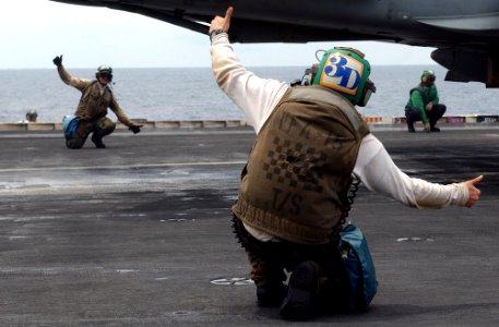 US Navy 030528-N-6141B-011 Final Checkers for the Valions of Strike Fighter Squadron Fifteen (VFA-15) give a thumbs up while preparing to launch