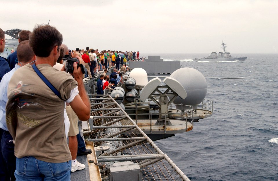 US Navy 030724-N-1328C-507 Crewmembers and their families watch as the guided missile destroyer USS Arleigh Burke (DDG 51) cruises by during a Tiger Cruise aboard USS Theodore Roosevelt (CVN 71)