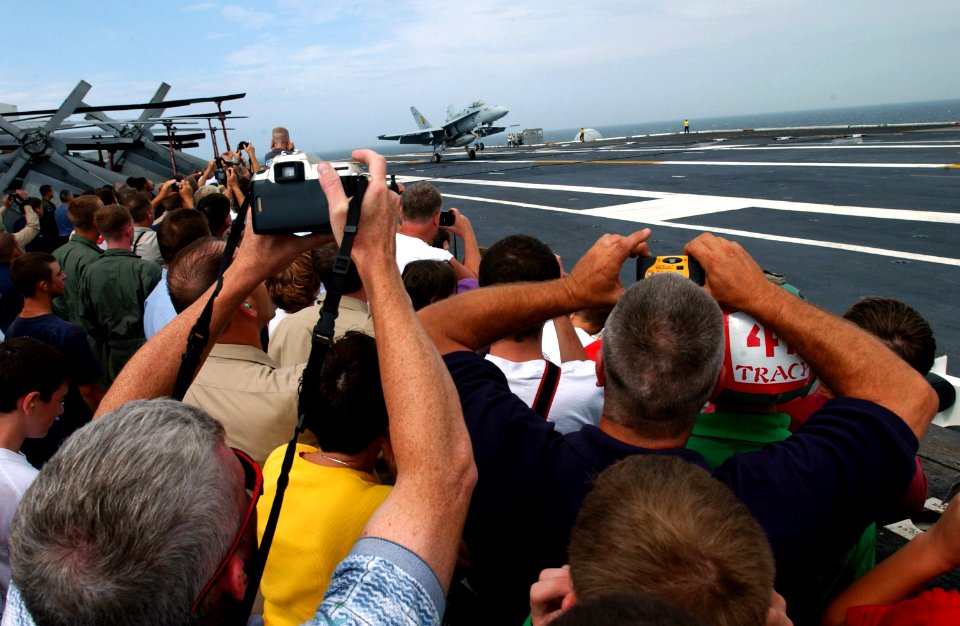 US Navy 030724-N-1328C-501 Crewmembers, family and friends enjoy as an F-A-18 make an arrested landing