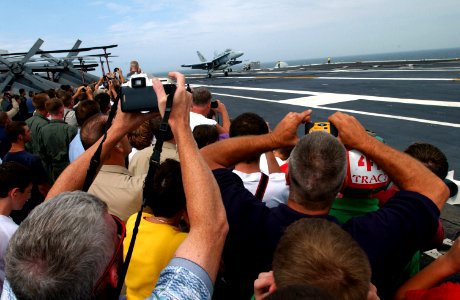 US Navy 030724-N-1328C-501 Crewmembers, family and friends enjoy as an F-A-18 make an arrested landing