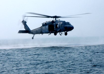 US Navy 030826-N-4374S-005 Search and Rescue swimmers assigned to the Chargers of Helicopter Combat Support Squadron Six (HC-6) stand ready aboard an MH-60S Knighthawk