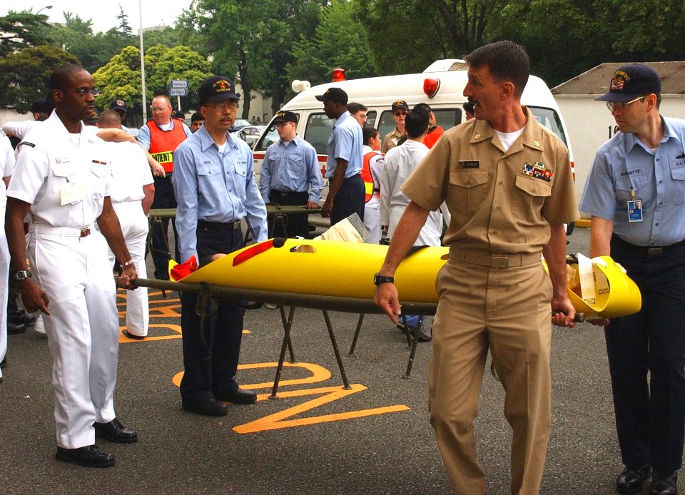 US Navy 030604-N-0000W-003 Chief Dental Technician Martin Stroud carries a simulated casualty into the Naval Hospital