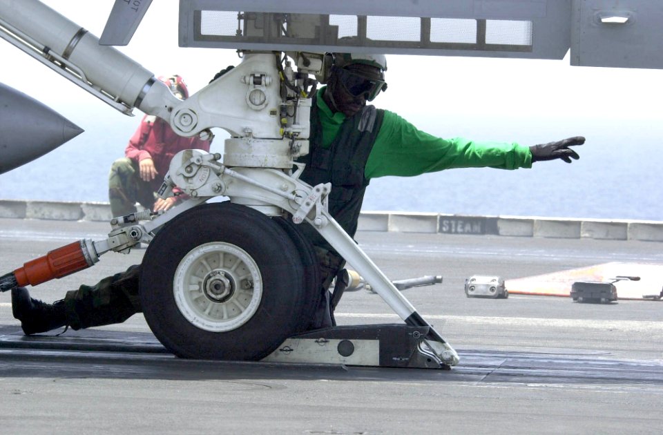 US Navy 030625-N-9319H-005 A Nimitz crewmember prepares an F-A-18 Hornet for launch on one of four steam driven catapults on the flight deck aboard USS Nimitz (CVN 68)