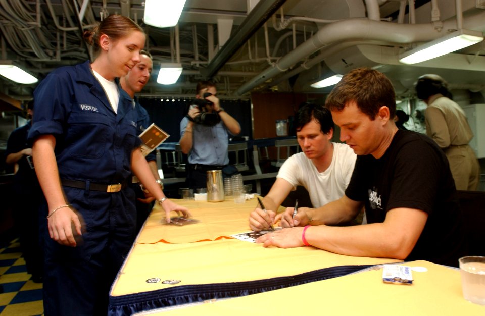 US Navy 030827-N-8273J-002 The rock bank Blink-182 Singer, bass guitarist Mark Hoppus and singer, guitarist Tom DeLonge sign autographs prior to a United Services Organization (USO) show aboard USS Nimitz