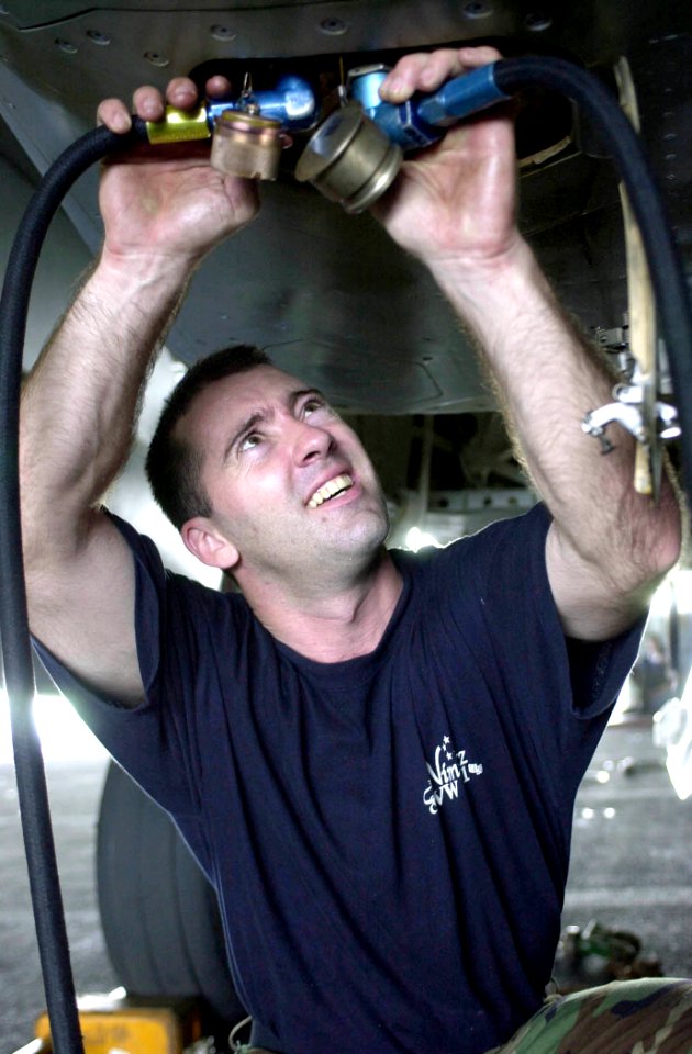 US Navy 030716-N-0413R-004 Aviation Machinist's Mate 3rd Class Jason Soileau from Baton Rouge, La., changes airframe mounted accessory drive oil from an aircraft in the Hangar Bay aboard USS Nimitz (CVN 68)
