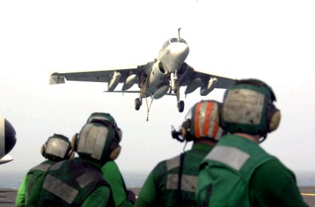 US Navy 030807-N-9319H-001 Crewmembers watch as an EA-6B Prowler comes in for an arrested landing on the flight deck of USS Nimitz (CVN 68) photo