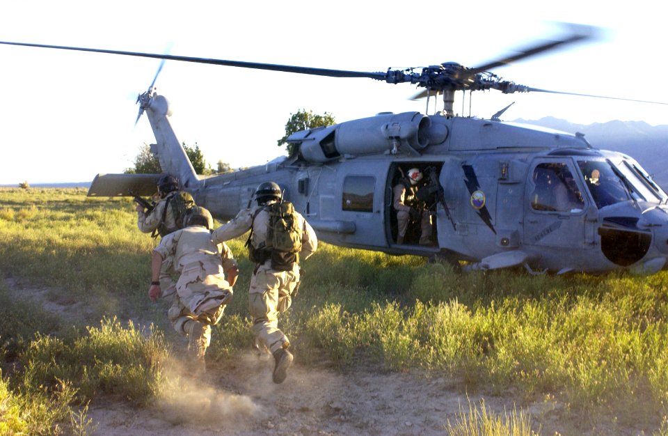 US Navy 030806-F-7823A-001 U.S. Navy SEAL (Sea, Air and Land) Team members secure a downed pilot for extraction at Naval Air Station (NAS) Fallon, Nev. as part of Desert Rescue XI