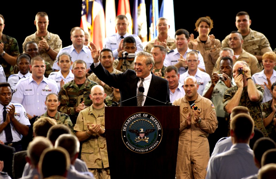 US Navy 030825-F-2828D-115 Secretary of Defense Donald H. Rumsfeld waves to members of the audience after being introduced during a town hall meeting at Lackland Air Force Base, San Antonio, Texas