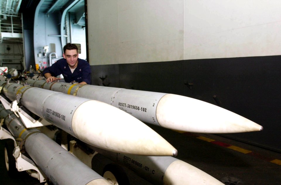 US Navy 030611-N-2143T-002 Aviation Ordnanceman 3rd Class Sean Foley from Philadelphia, Pa., moves Air Interceptor Missile 120 (AIM-120) to a weapons elevator for transfer to the flight deck aboard USS Nimitz (CVN 68)