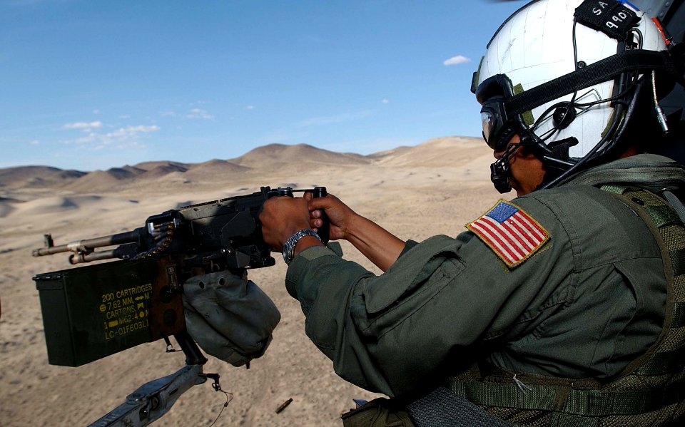 US Navy 030805-F-4884R-008 Aviation Warfare Systems Operator 2nd Class Steve Alcaraz, a door gunner assigned to Helicopter Anti-Submarine Squadron Two (HS-2), fires an M-240 machine gun during Desert Rescue XI