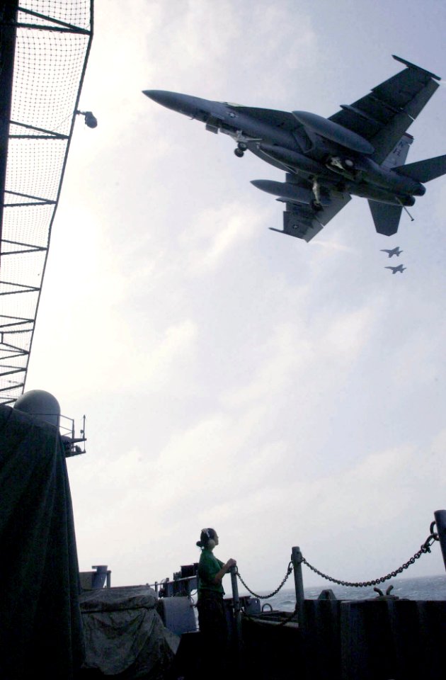 US Navy 030806-N-2143T-003 Airman Patricia Guillen, of Los Angeles, Calif., watches an F-A-18E Super Hornet line up for an arrested landing on the flight deck of USS Nimitz (CVN 68)