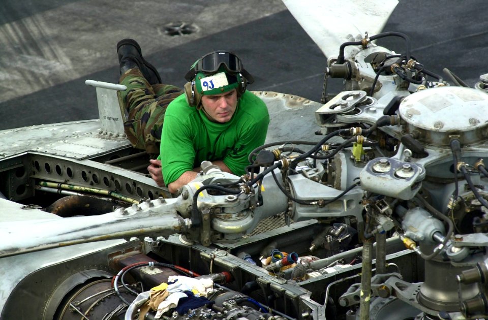 US Navy 030921-N-9319H-001 Aviation Machinist's Mate 3rd Class Joseph Minneman removes an axial fan assembly