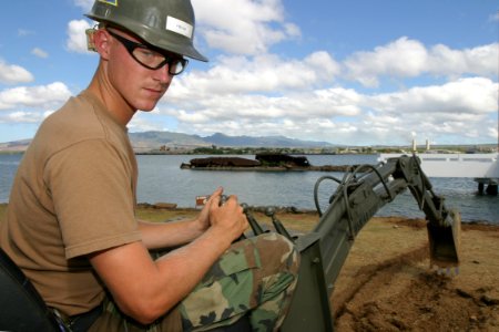 US Navy 030827-N-3228G-001 Equipment Operator Construction Apprentice Ryan Fuller assigned to Construction Battalion Unit 413 (CBU-413) removes ground cover from the lawn of the USS Utah Memorial on Ford Island