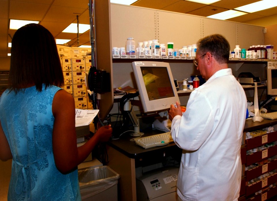 US Navy 030819-N-9593R-082 Pharmacist Randal Heller, right, verifies the dosage and medication of a prescription at the National Naval Medical Center in Bethesda, Maryland