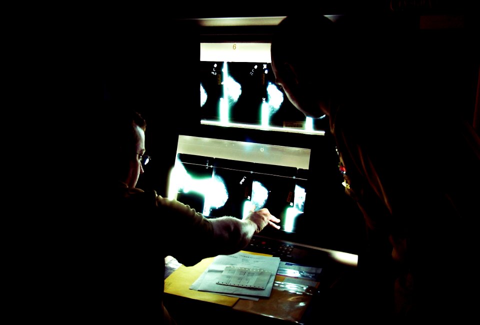 US Navy 030820-N-9593R-007 U.S. Navy doctors Lt. Cmdr Ralph Pickard, left, and Ens. Jesse Rohloff study a patient's mammogram film at the National Naval Medical Center in Bethesda, Maryland