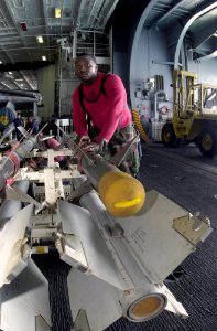 US Navy 030815-N-2143T-002 Aviation Ordinanceman 3rd Class Odel Mason, from Richmond, Calif., transfers an AIM-9 Sidewinder to a weapons elevator