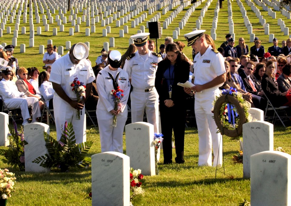 US Navy 030911-N-9593R-005 Navy personnel pause for a moment with a family member after laying flowers at a grave marker in Arlington National Cemetery