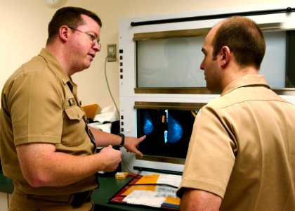 US Navy 030820-N-9593R-004 U.S. Navy doctors Lt. Cmdr Ralph Pickard, left, and Ens. Jesse Rohloff study a patient's mammography film at the National Naval Medical Center in Bethesda, Md photo