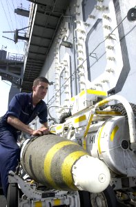 US Navy 030906-N-2143T-003 Aviation Ordnanceman 3rd Class Obed Melendez, from Manati, Puerto Rico, pushes a Guided Bomb Unit to the bomb farm
