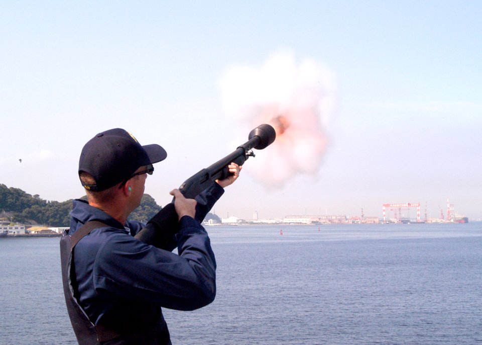 US Navy 030918-N-8955H-014 Master-at-Arms 2nd Class Dave Shull, Jr. from Orlando, Fla., shoots a non-lethal sting ball grenade