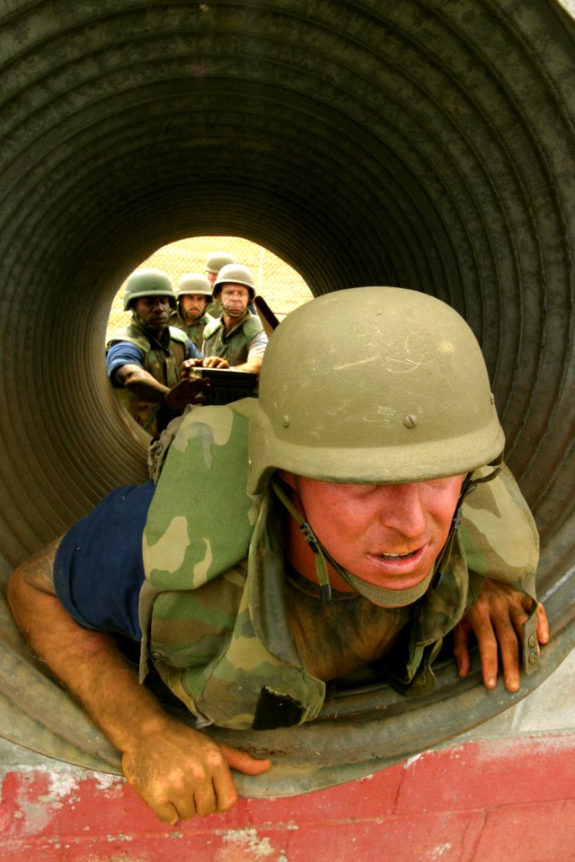 US Navy 030822-N-3228G-010 A chief petty officer selectee from USS Reuben James (FFG 57) exits a pipe while his teammates prepare to assist him on the leadership reaction course