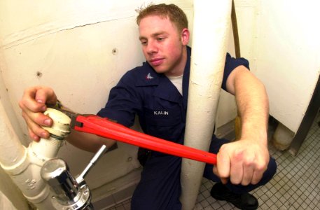 US Navy 030923-N-2143T-003 Hull Maintenance Technician 3rd Class Kevin Kalin from Denver, Colo., uses a wrench to perform repairs